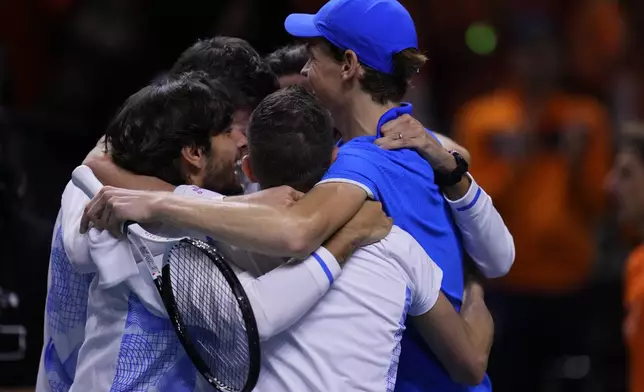 Italy's Jannik Sinner celebrates with teammates after defeating Netherlands' Tallon Griekspoor during the Davis Cup final tennis match between Netherlands and Italy at the Martin Carpena Sports Hall in Malaga, southern Spain, Sunday, Nov. 24, 2024. (AP Photo/Manu Fernandez)