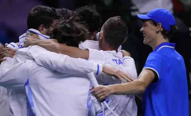 Italy's Jannik Sinner, right, celebrates with teammates after defeating Netherlands' Tallon Griekspoor to win Italy's second consecutive Davis Cup title at the Martin Carpena Sports Hall in Malaga, southern Spain, Sunday, Nov. 24, 2024. (AP Photo/Manu Fernandez)