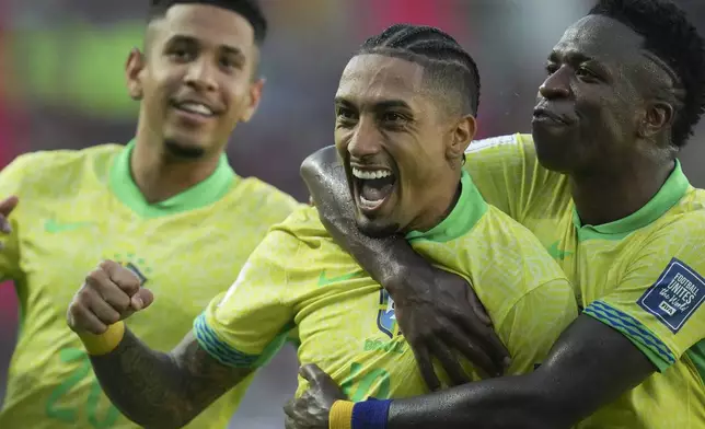 Brazil's Raphinha, center, celebrates with teammate Vinicius Junior, right, after scoring his side's opening goal against Venezuela during a FIFA World Cup 2026 qualifying soccer match at Monumental stadium in Maturin, Venezuela, Thursday, Nov. 14, 2024. (AP Photo/Ariana Cubillos)
