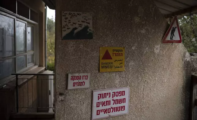 A sign alerting there danger of mines decorates a wall of the house for teenagers residents of the Kibbutz Malkiya, in the upper Galilee, northern Israel, Wednesday, Nov. 27, 2024. (AP Photo/Leo Correa)