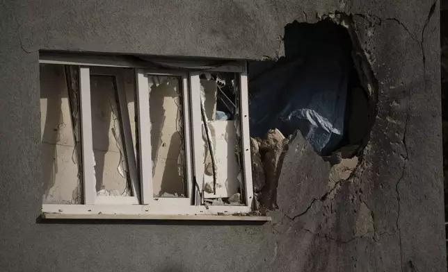 A hole next to a window shows the impact of a rocket fired from Lebanon, on a house of the Kibbutz Manara, located in the upper Galilee, northern Israel, Thursday, Nov. 28, 2024. (AP Photo/Leo Correa)