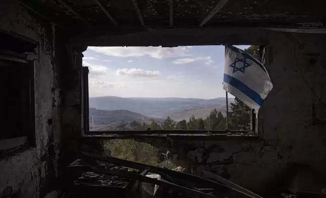 A Lebanese village is seen through a window of a damaged house that was hit by a rocket fired from Lebanon, in the Kibbutz Manara, located in the upper Galilee, northern Israel, Thursday, Nov. 28, 2024. (AP Photo/Leo Correa)