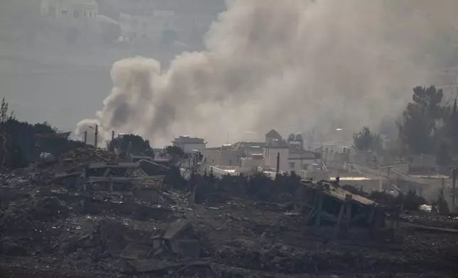 Smoke rise next to damaged buildings on an area of a village in southern Lebanon, as seen from the Kibbutz Manara, northern Israel, Thursday, Nov. 28, 2024. (AP Photo/Leo Correa)