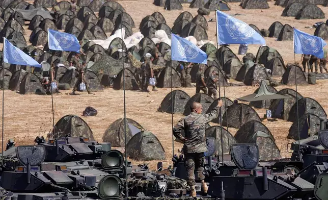 FILE - A Spanish U.N. peacekeeper stands atop an armored personnel carrier as U.N. flags are seen in the Spanish troops' new base in the southern village of Taibeh, Lebanon, Sunday, Sept. 17, 2006, as they joined the expansion of the UNIFIL peacekeeping force in Lebanon under a new Security Council resolution. (AP Photo/Alvaro Barrientos, File)