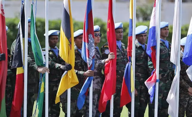 FILE - Peacekeepers representing 41 different national contingents that make up the United Nations Interim Force in Lebanon (UNIFIL), prepare to raise flags during a ceremony to mark the 40th anniversary of its peacekeeping presence in southern Lebanon, at the mission headquarters in the coastal town of Naqoura, Lebanon, Monday, March 19, 2018. (AP Photo/Hassan Ammar, File)