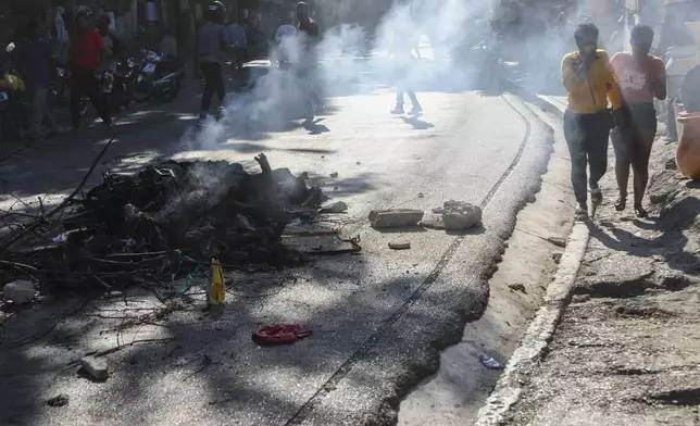 The bodies of suspected gang members who were set on fire by residents, sit in a pile in the middle of a road in the Pétion-Ville neighborhood of Port-au-Prince, Haiti, Tuesday, Nov. 19, 2024. (AP Photo/Odelyn Joseph)