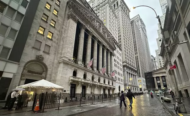 People walk past the New York Stock Exchange on Tuesday, Nov. 26 2024. (AP Photo/Peter Morgan)