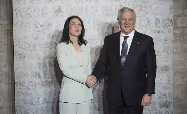 Italian Foreign Minister Antonio Tajani, greets German Foreign Minister Annalena Baerbock, as she arrives for a family photo at the G7 of foreign Ministers in Anagni, some 70 kilometers south-east of Rome, Monday, Nov. 25, 2024. (AP Photo/Alessandra Tarantino)