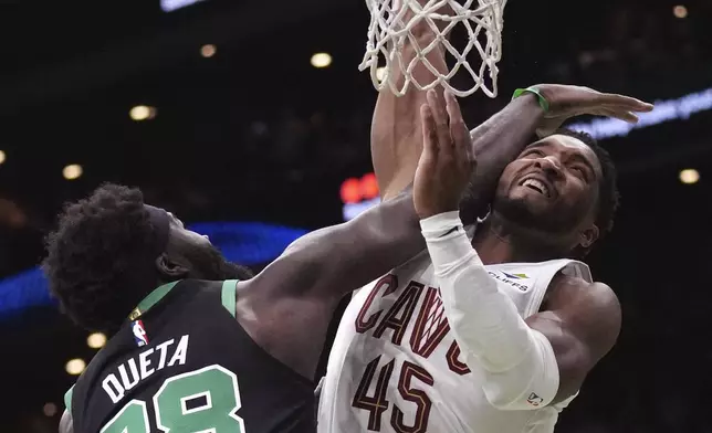 Boston Celtics center Neemias Queta (88) fouls Cleveland Cavaliers guard Donovan Mitchell (45) on a drive to the basket during the first half of an Emirates NBA Cup basketball game, Tuesday, Nov. 19, 2024, in Boston. (AP Photo/Charles Krupa)