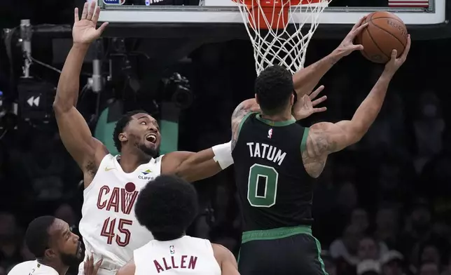 Boston Celtics forward Jayson Tatum (0) drives to the basket against Cleveland Cavaliers guard Donovan Mitchell (45) during the first half of an Emirates NBA Cup basketball game, Tuesday, Nov. 19, 2024, in Boston. (AP Photo/Charles Krupa)