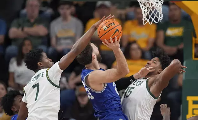 New Orleans forward Luke Davis (20) has his shot blocked by Baylor's VJ Edgecombe (7) as Norchad Omier (15) helps defend on the play in the first half of an NCAA college basketball game Wednesday, Nov. 27, 2024, in Waco, Texas. (AP Photo/Tony Gutierrez)