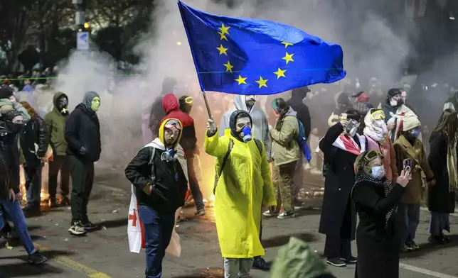 A protester waves an European Union flag during a rally outside the parliament to protest the government's decision to suspend negotiations on joining the European Union for four years in Tbilisi, Georgia, early Saturday, Nov. 30, 2024. (AP Photo/Zurab Tsertsvadze)