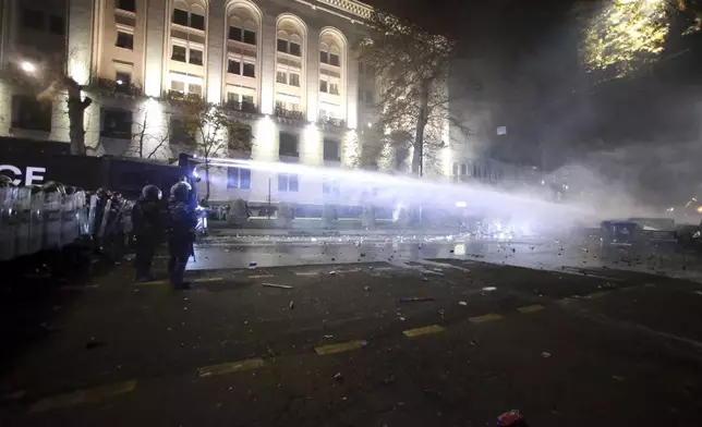 Police use a water cannon to prevent protesters rallying against the governments' decision to suspend negotiations on joining the European Union for four years, outside the parliament's building in Tbilisi, Georgia, early Saturday, Nov. 30, 2024. (AP Photo/Zurab Tsertsvadze)