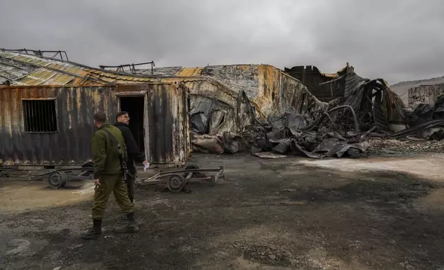 Israel soldiers walk next to a damaged animal farm hit by a rocket fired from Lebanon in Avivim, northern Israel, near the border with Lebanon, Wednesday, Nov. 27, 2024. (AP Photo/Francisco Seco)