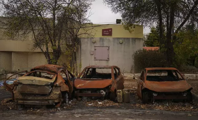 Burned cars hit by a rocket fired from Lebanon rest next to a synagogue in Avivim, northern Israel, near the border with Lebanon, Wednesday, Nov. 27, 2024. (AP Photo/Francisco Seco)