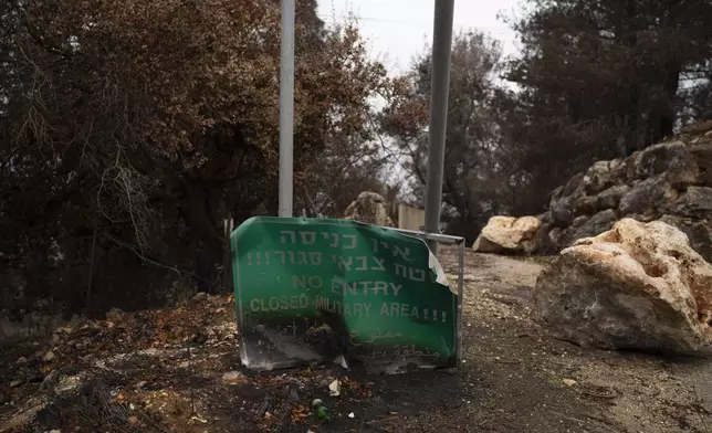 A damaged sign alerting a closed military area sits near the Israeli-Lebanese border, as seen from northern Israel, Wednesday, Nov. 27, 2024. (AP Photo/Leo Correa)