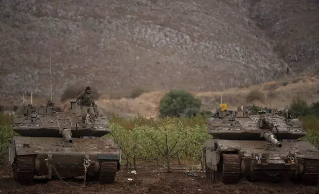 An Israeli soldier stands on the top of a tank on an area near the Israeli-Lebanese border, as seen from northern Israel, Wednesday, Nov. 27, 2024. (AP Photo/Leo Correa)