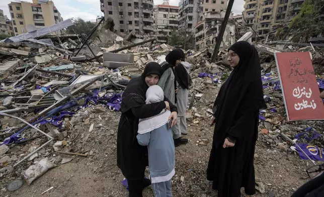 A woman hugs her crying daughter as displaced residents return to Dahiyeh, in Beirut, Lebanon, following a ceasefire between Israel and Hezbollah, Wednesday, Nov. 27, 2024. (AP Photo/Bilal Hussein)