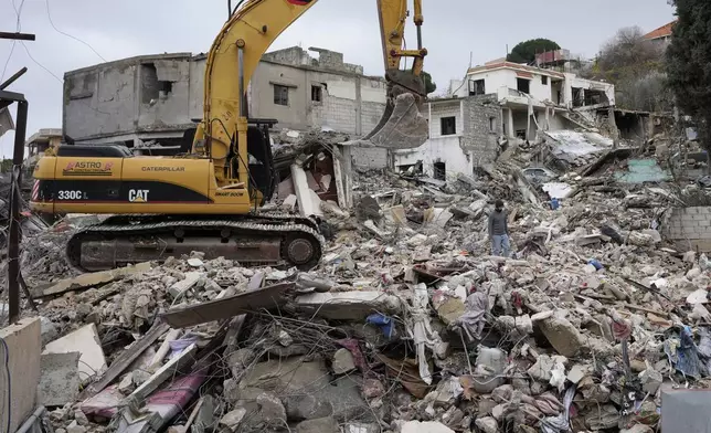 Rescuers use an excavator as they search for dead bodies through the rubble of a destroyed house, following a ceasefire between Israel and Hezbollah that went into effect on Wednesday, Nov. 27, 2024, in Ainata village, south Lebanon. (AP Photo/Hussein Malla)