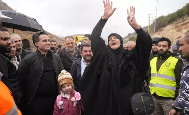 Caretaker Transportation Minister Ali Hamieh, left, welcomes displaced residents returning from Syria at the Masnaa border crossing, eastern Lebanon, following a ceasefire between Israel and Hezbollah on Wednesday, Nov. 27, 2024. (AP Photo/Hassan Ammar)