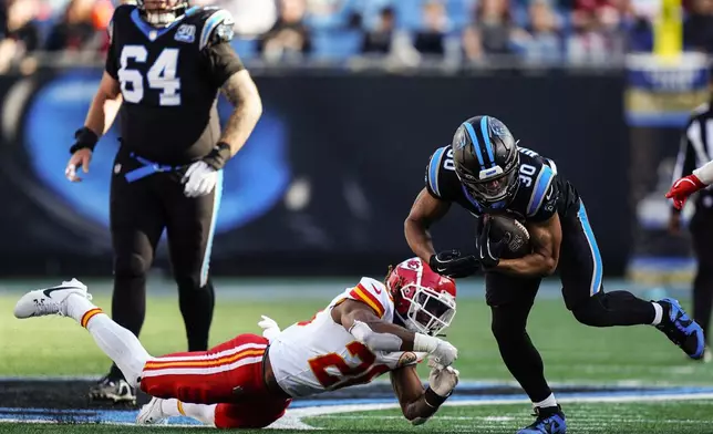 Carolina Panthers running back Chuba Hubbard (30) runs against Kansas City Chiefs safety Justin Reid (20) during the second half of an NFL football game, Sunday, Nov. 24, 2024, in Charlotte, N.C. (AP Photo/Jacob Kupferman)