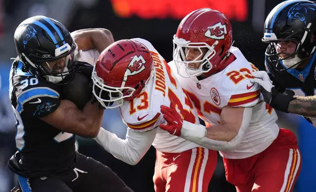 Kansas City Chiefs safety Nazeeh Johnson (13) hits Carolina Panthers running back Chuba Hubbard (30) during the second half of an NFL football game, Sunday, Nov. 24, 2024, in Charlotte, N.C. (AP Photo/Rusty Jones)