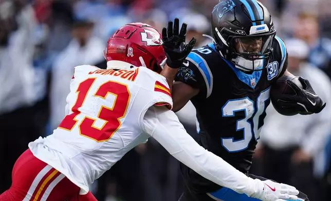 Carolina Panthers running back Chuba Hubbard (30) runs against Kansas City Chiefs safety Nazeeh Johnson (13) during the second half of an NFL football game, Sunday, Nov. 24, 2024, in Charlotte, N.C. (AP Photo/Jacob Kupferman)