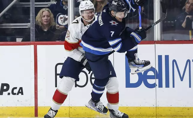 Florida Panthers' Dmitry Kulikov (7) trips Winnipeg Jets' Vladislav Namestnikov (7) during the second period of an NHL hockey game in Winnipeg, Manitoba, Tuesday, Nov. 19, 2024. (Fred Greenslade/The Canadian Press via AP)