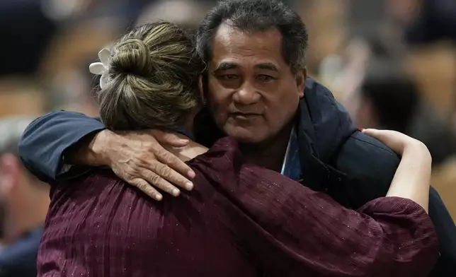 Toeolesulusulu Cedric Schuster, Samoa environment minister, right, embraces an attendee during a closing plenary session at the COP29 U.N. Climate Summit, Sunday, Nov. 24, 2024, in Baku, Azerbaijan. (AP Photo/Rafiq Maqbool)