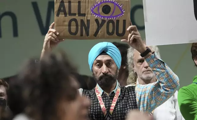 Activist Harjeet Singh holds a sign as he attends a demonstration for climate finance at the COP29 U.N. Climate Summit, Saturday, Nov. 23, 2024, in Baku, Azerbaijan. (AP Photo/Sergei Grits)