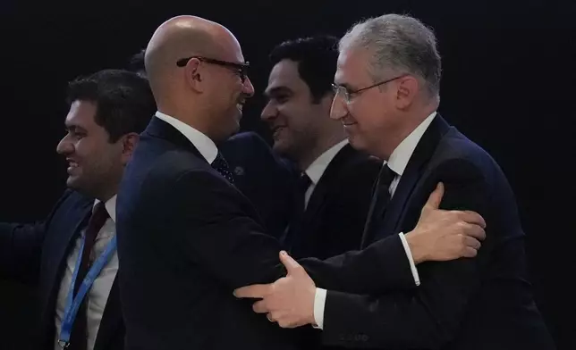 Mukhtar Babayev, COP29 President, right, embraces Simon Stiell, United Nations climate chief, after gaveling a deal for money to curb climate change at the COP29 U.N. Climate Summit, Sunday, Nov. 24, 2024, in Baku, Azerbaijan. (AP Photo/Rafiq Maqbool)