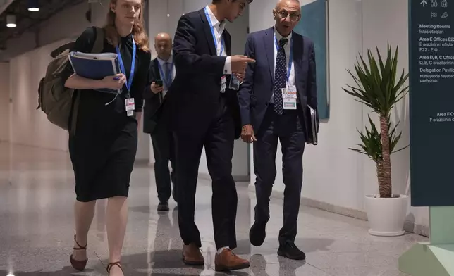 John Podesta, U.S. climate envoy, right, walks through the hallways of the COP29 U.N. Climate Summit in the early hours of Saturday, Nov. 23, 2024, in Baku, Azerbaijan. (AP Photo/Joshua A. Bickel)