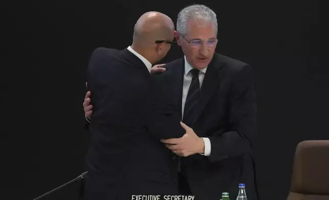 Mukhtar Babayev, COP29 President, right, and Simon Stiell, United Nations climate chief, embrace after a plenary session at the COP29 U.N. Climate Summit, Saturday, Nov. 23, 2024, in Baku, Azerbaijan. (AP Photo/Sergei Grits)