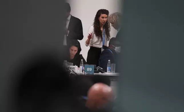 Jennifer Morgan, Germany climate envoy, right, and Joanna MacGregor, senior advisor for U.N. climate change, talk near Germany Foreign Minister Annalena Baerbock, bottom left, in a meeting room at the COP29 U.N. Climate Summit, Saturday, Nov. 23, 2024, in Baku, Azerbaijan. (AP Photo/Peter Dejong)