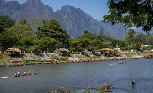 Foreign tourists ride on boat in a river in Vang Vieng, Laos, Friday, Nov. 22, 2024. (AP Photo/Anupam Nath)