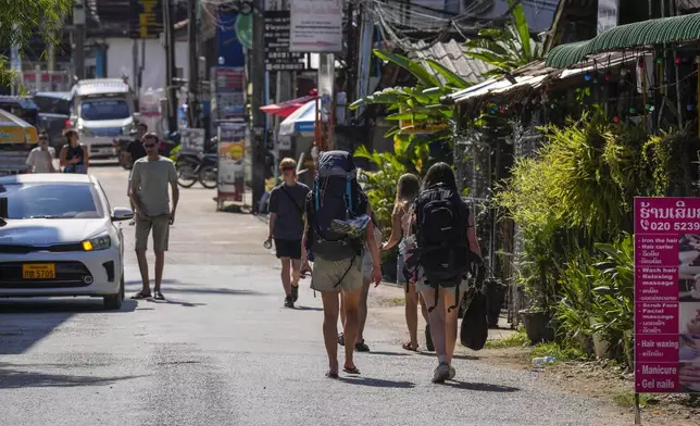 Backpacker foreign tourists roam around in Vang Vieng, Laos, Friday, Nov. 22, 2024. (AP Photo/Anupam Nath)