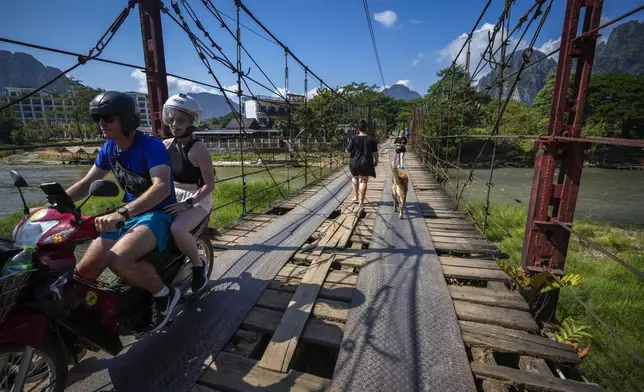 Foreign tourists roam around in Vang Vieng, Laos, Friday, Nov. 22, 2024. (AP Photo/Anupam Nath)