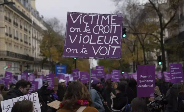 A protestor holds a placard reading "Victim we believe you. Rapist we see you" during a march for the International Day for the Elimination of Violence Against Women in Paris, France, Saturday, Nov. 23, 2024. (AP Photo/Thibault Camus)