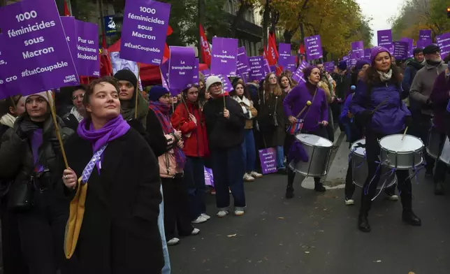 A protester, front left, holds placard reading "1000 feminicides under Macron presidency " during a march for the International Day for the Elimination of Violence Against Women in Paris, France, Saturday, Nov. 23, 2024. (AP Photo/Thibault Camus)