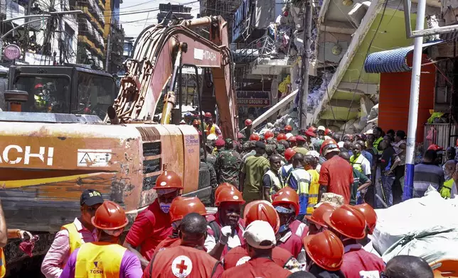 CORRECTS NATIONALITY OF RESCUE WORKERS - Rescue workers from the Tanzania Red Cross attend the scene of a building that collapsed in Dar es Salaam, Tanzania, Saturday, Nov. 16, 2024. (AP Photo)