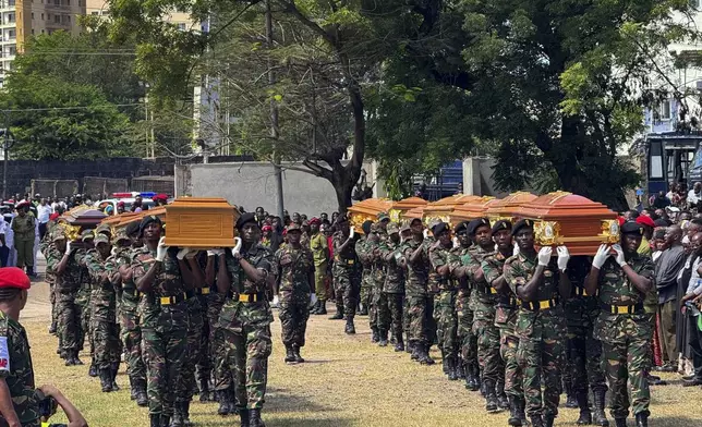 Military officers carry coffins in Dar es Salaam, Tanzania Monday, Nov. 18, 2024 during a funeral ceremony for the people who died in a building that collapsed in Dar es Salaam on Saturday. (AP Photo/Steven Genya)