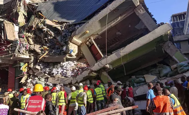 People attend the scene of a building that collapsed in Dar es Salaam, Tanzania, Sunday, Nov. 17, 2024. (AP Photo/Steven Genya)