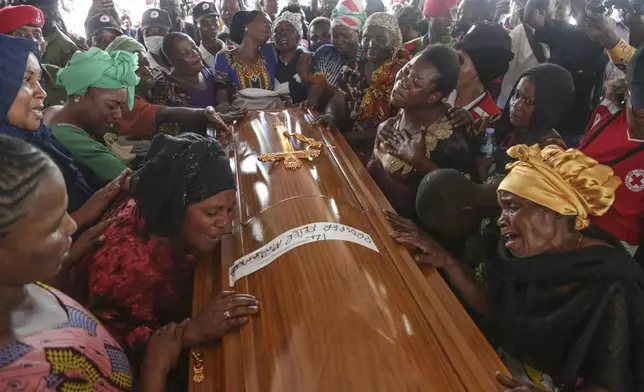 Relatives cry at a coffin in Dar es Salaam, Tanzania Monday, Nov. 18, 2024 during a funeral ceremony for the people who died in a building that collapsed in Dar es Salaam on Saturday. (AP Photo)