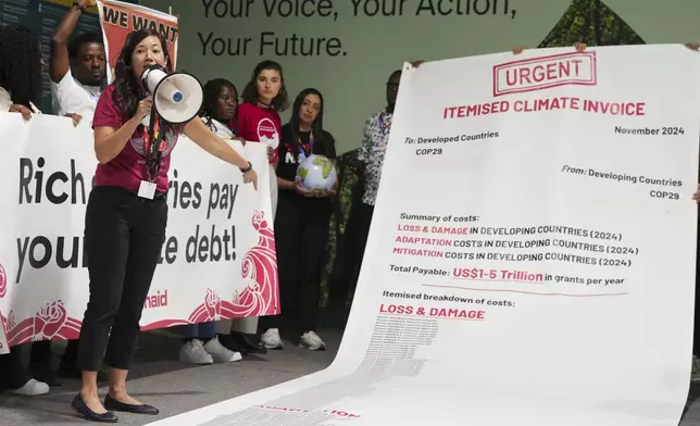 Activist Teresa Anderson leads a demonstration calling for climate finance during the COP29 U.N. Climate Summit, Thursday, Nov. 14, 2024, in Baku, Azerbaijan. (AP Photo/Peter Dejong)