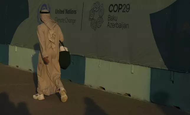 A person walks past a sign for the COP29 U.N. Climate Summit, Friday, Nov. 15, 2024, in Baku, Azerbaijan. (AP Photo/Peter Dejong)