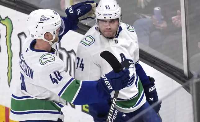 Vancouver Canucks left wing Jake DeBrusk (74) is congratulated by Elias Pettersson (40) after his goal against Boston Bruins goaltender Jeremy Swayman during the second period of an NHL hockey game, Tuesday, Nov. 26, 2024, in Boston. (AP Photo/Charles Krupa)