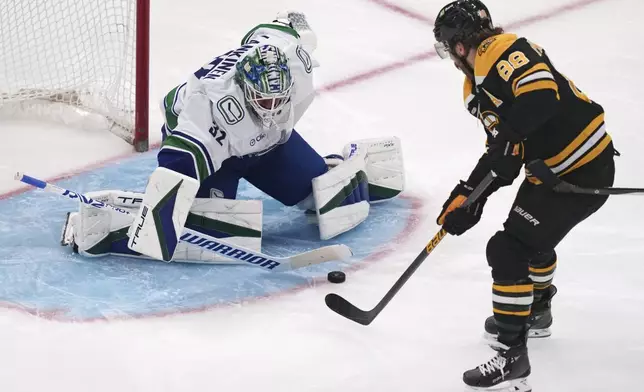 Vancouver Canucks goaltender Kevin Lankinen drops his stick to the ice on a shot by Boston Bruins right wing David Pastrnak (88) during the second period of an NHL hockey game, Tuesday, Nov. 26, 2024, in Boston. (AP Photo/Charles Krupa)