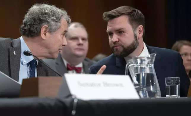 FILE - Sen. JD Vance, R-Ohio, right, speaks with Sen. Sherrod Brown, D-Ohio, before testifying at a hearing, March 9, 2023, in Washington. (AP Photo/Kevin Wolf, File)