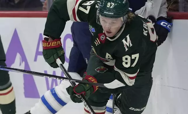 Minnesota Wild left wing Kirill Kaprizov (97) skates with the puck as Winnipeg Jets center Rasmus Kupari (15) follows during the first period of an NHL hockey game, Monday, Nov. 25, 2024, in St. Paul, Minn. (AP Photo/Abbie Parr)