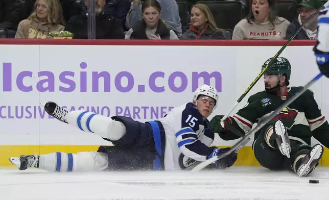 Winnipeg Jets center Rasmus Kupari (15) and Minnesota Wild center Marcus Johansson, right, collide during the third period of an NHL hockey game, Monday, Nov. 25, 2024, in St. Paul, Minn. (AP Photo/Abbie Parr)